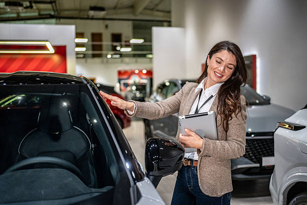 istock Saleswoman using tablet showing new car to customer 2252830294