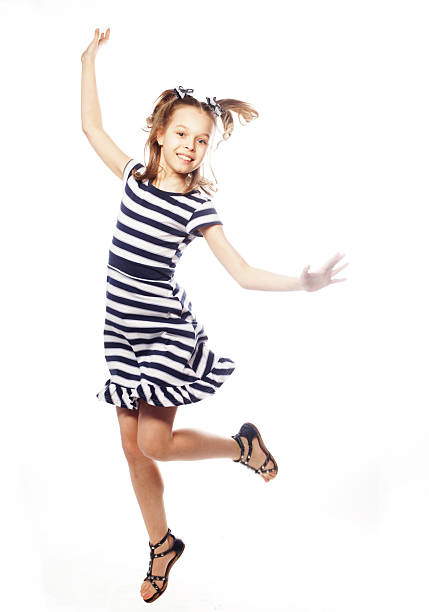Young Japanese American Woman Jumping In Short Dress Arms And Legs Out With Big Smile On Black Background