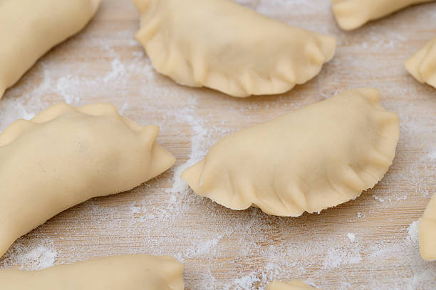 istock Polish pierogi isolated on a floured board, uncooked 2252831168