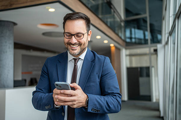 istock Smiling businessman using smartphone in corporate office 2252831647
