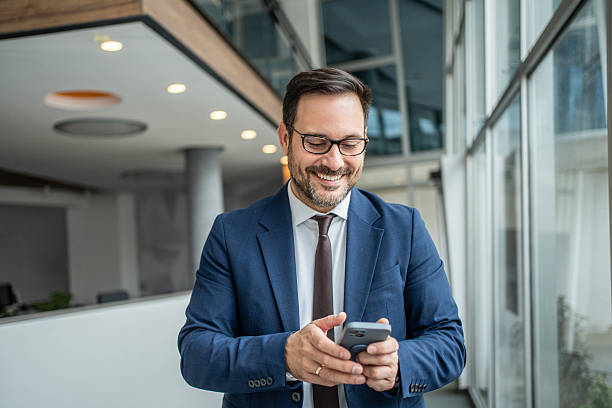 istock Successful businessman smiling using phone in modern office 2252831666