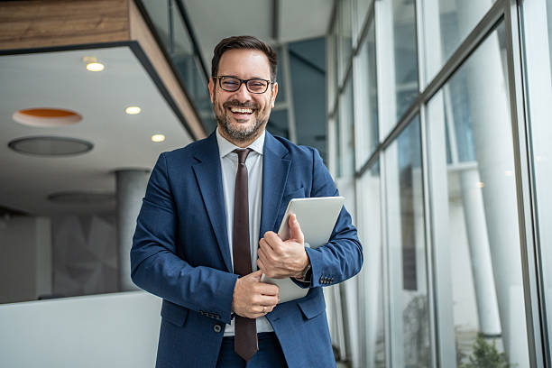 istock Happy businessman holding a tablet in office hallway 2252831904