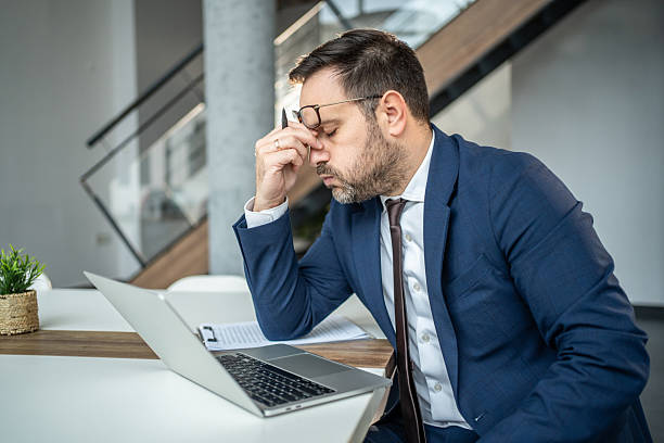 istock Overworked businessman experiencing stress and headache working late 2252832558