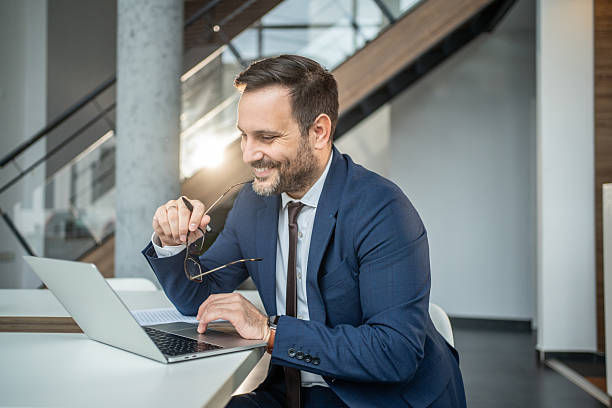 istock Smiling businessman working on laptop in modern office 2252832568
