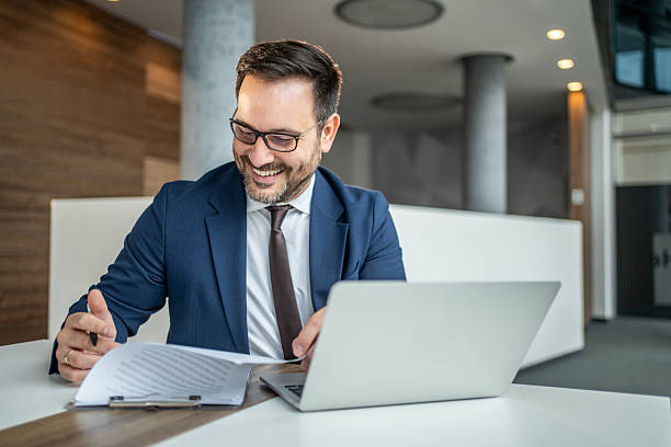 istock Businessman happily working on laptop and reviewing documents in office 2252832572