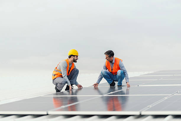 istock Renewable energy workers inspecting solar panels on rooftop 2252837523