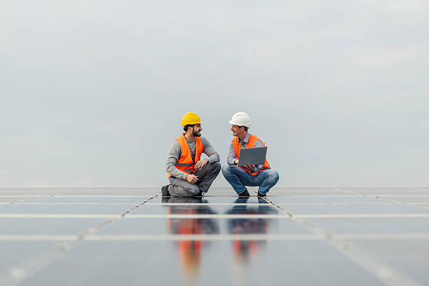 istock Engineers inspecting solar panels with laptop on rooftop 2252837566