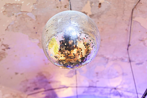 Hanging Mirror Ball Under Industrial Ceiling With Purple Wash And Scattered Light, Exposed Concrete