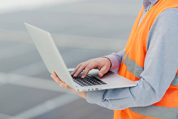 istock Construction worker operating laptop wearing safety vest 2252837721