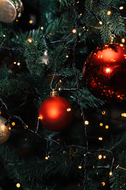 istock Red and gold ornaments hang on a Christmas tree with string lights glowing. The scene captures the festive spirit of the holiday season, showcasing the decorations on the tree 2252838201