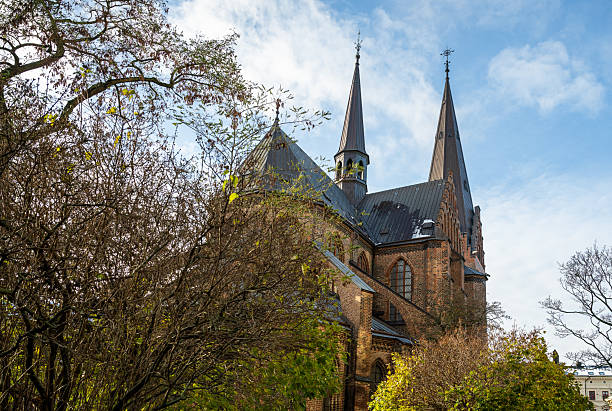 istock Gothic brick church with twin spires surrounded by autumn trees 2252838249