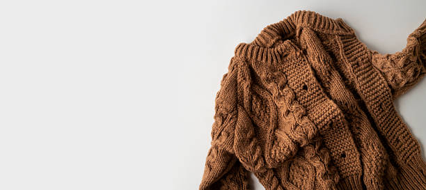 istock Knitted brown wool children's sweater, cardigan with buttons, pullover on light background top view. Autumn winter cozy warm cotton sweater with large pattern ornament. Stylish clothes fashion, mockup 2252839516