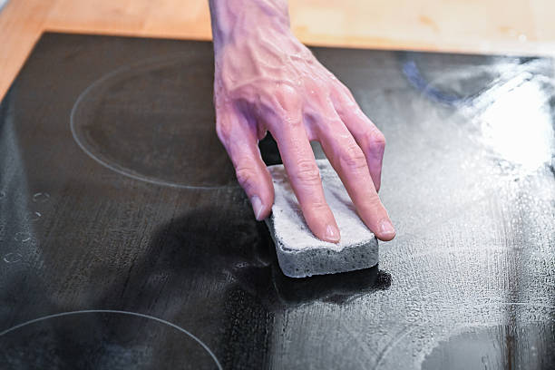 istock Hand cleaning ceramic cooktop with sponge in modern kitchen 2252842318