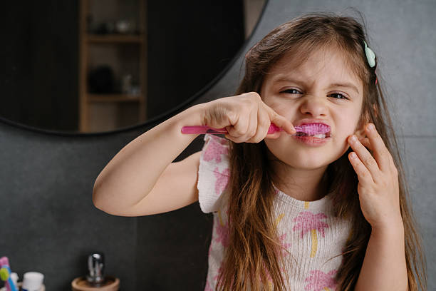 istock white girl making funny face while brushing teeth closeup 2252843127