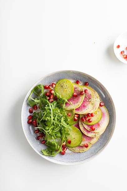 istock Sliced winter pink radishes on plate top view 2252845452