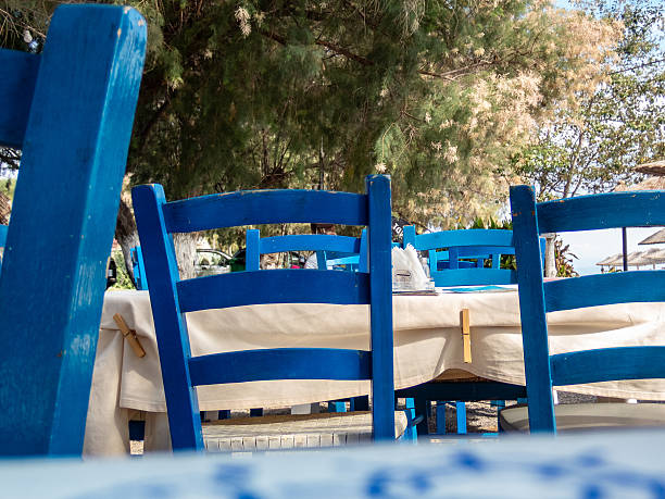 Chairs on street of typical greek traditional village with white houses on Mykonos Island, Greece