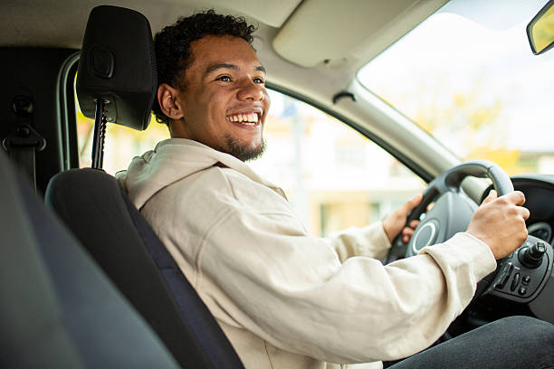 istock Man smiling sitting in a car, front seat view 2252856503