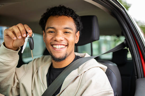 istock Smiling man holding car keys with seat belt fastened 2252856574