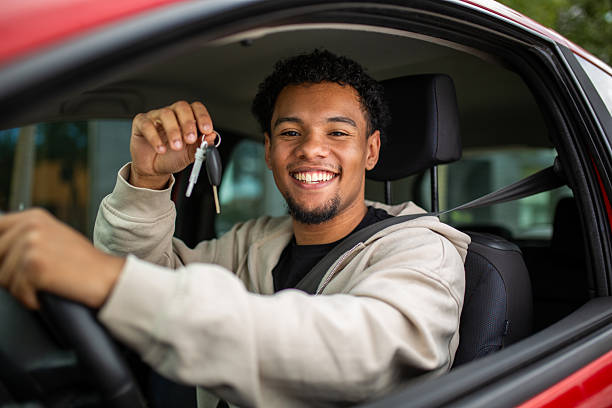 istock Smiling man in car holding keys through window 2252856588