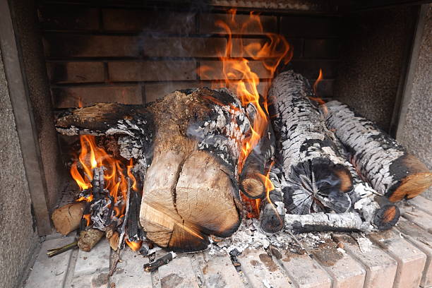 Burning firewood in a brick fireplace generates a cozy, warm atmosphere, perfect for winter relaxation and comfort in any home