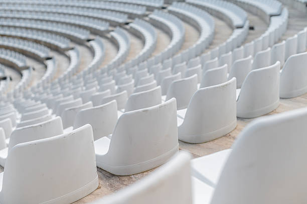 istock Rows of empty white seats arranged in a circular pattern inside a large outdoor venue during the day 2252859968