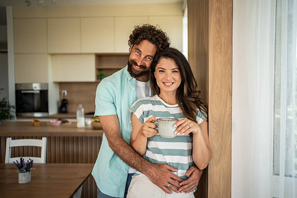 istock Happy couple embracing in modern kitchen at home 2252860064