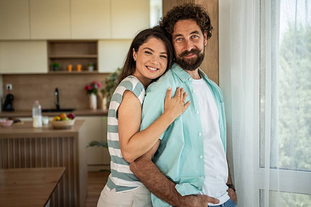 istock Happy couple embracing in kitchen at home 2252860325