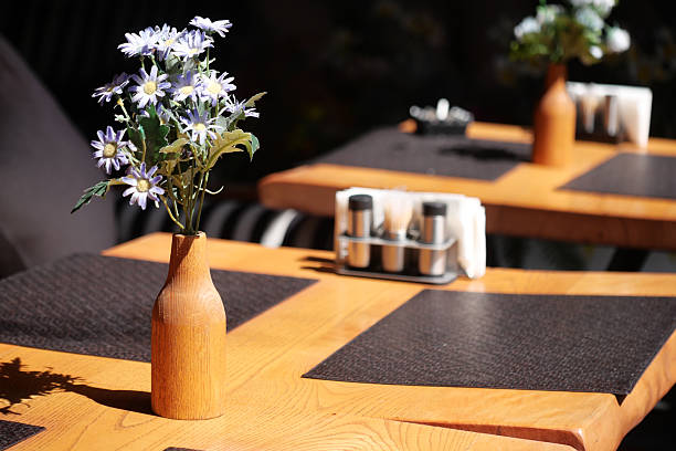 Bright outdoor tables arranged with flowers and condiments for dining.