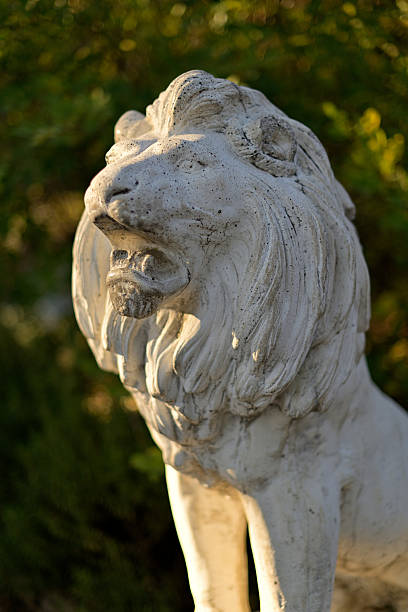istock Majestic Stone Lion Statue in Garden Setting 2252864007