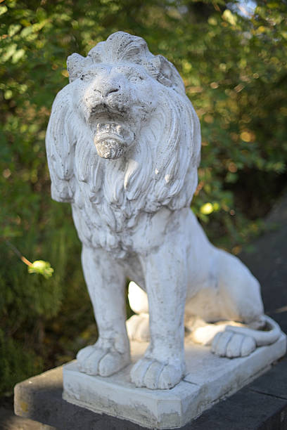 istock Majestic Stone Lion Statue in Garden Setting 2252864065