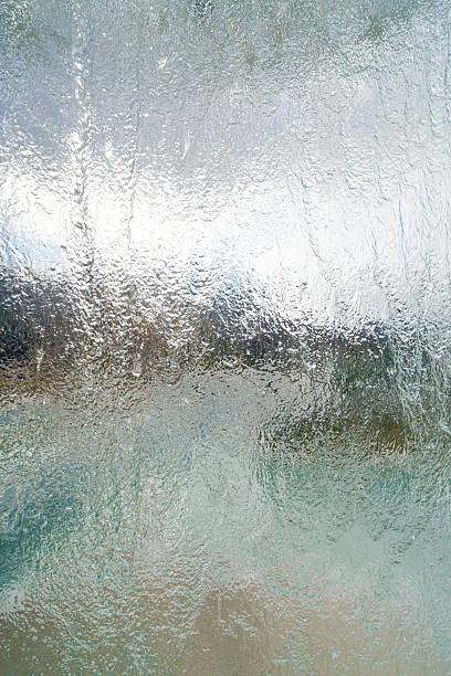 istock close-up dynamic texture of water flowing down a transparent surface glass panel. Use as a background, texture overlay, or for themes related to freshness, cleanliness, nature, and tranquility. 2252864156