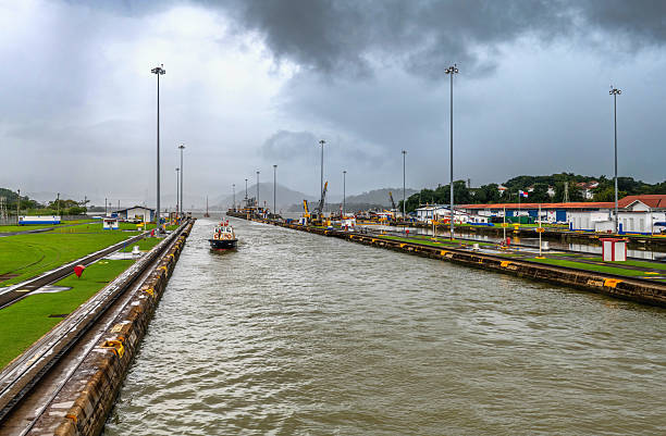 Panama City, Panama, November 30, 2025: A boat is sailing through the lock of the Panama Canal under cloudy sky.