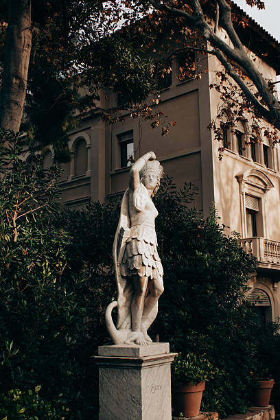 Decorative sculpted head and floral architectural details adorn this historic column in Venice, Italy. The artwork features intricate craftsmanship and evokes a sense of classical design and artistic heritage.