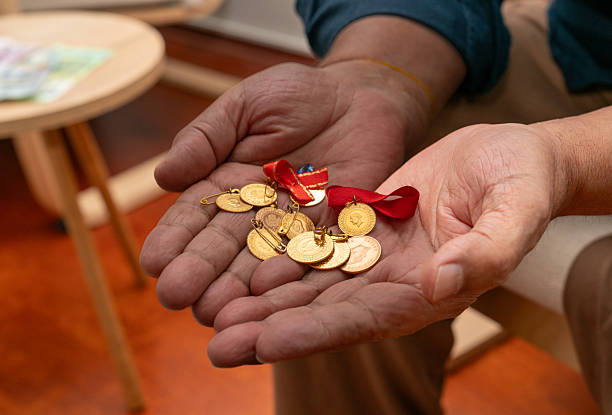 istock Man with gold coins in the hand 2252885485