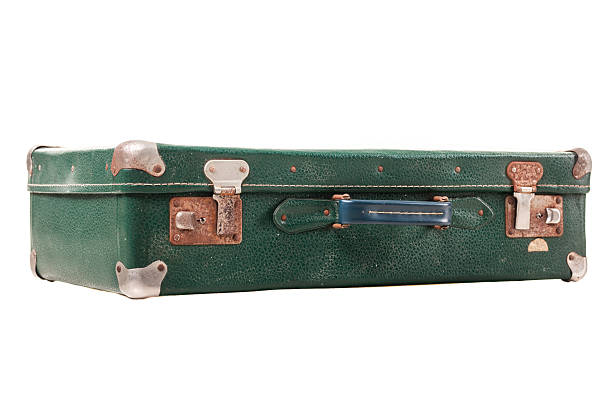 istock A green vintage suitcase with metal accents is placed on a plain surface. Its worn exterior and sturdy design hint at many journeys it has experienced and adventures it has held 2252893473