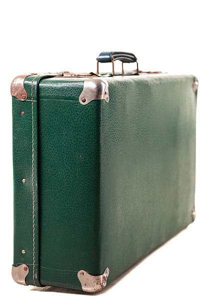 istock A vintage green suitcase stands upright, featuring a textured surface and reinforced corners. This classic luggage piece evokes memories of past journeys and adventures 2252893474