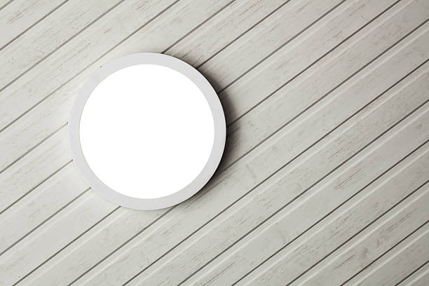 A circular light fixture is mounted on a white wood panel ceiling, providing a clean and contemporary illumination. The design enhances the room's bright and inviting ambiance