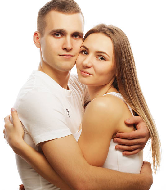 A guy and a girl press their cheeks against each other. Close-up of their eyes.