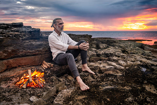 istock Solitary Man Reflecting by Campfire at Sunset 2252899212