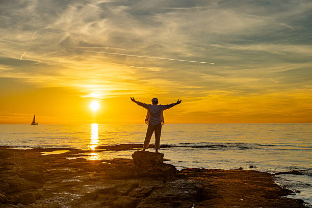 istock Silhouette of a Man Embracing Triumph at Sunset 2252899232