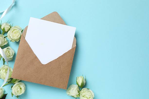 istock Beautiful white roses with paper envelope on color background 2252899377