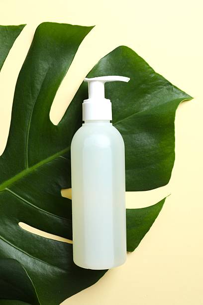 istock Cosmetic bottle with monstera leaf on colored background 2252900993