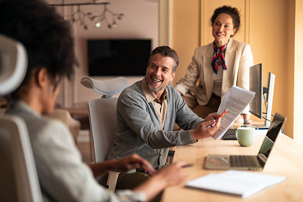 istock Smiling Team Members Share a Document During a Friendly Business Meeting in a Modern Office 2252901736