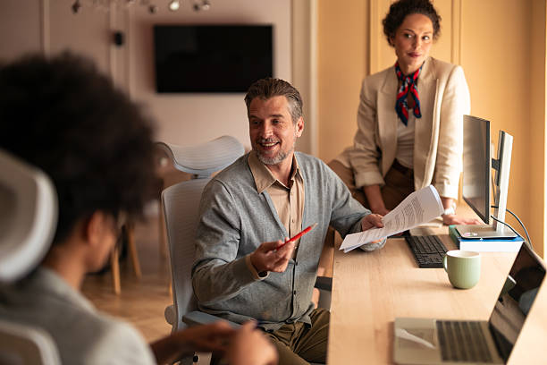 istock Friendly Office Meeting With Colleagues Discussing Documents And Ideas In A Modern Workspace 2252901741