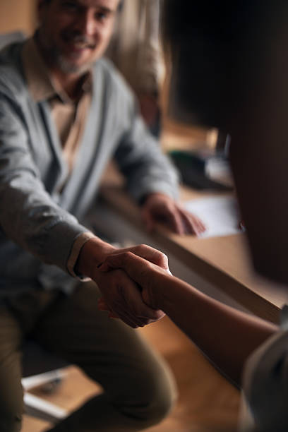 istock Handshake Between Colleagues Across a Desk in Warm Lighting Signifying Trust and Collaboration 2252901746