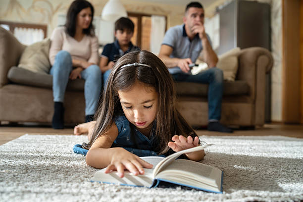 istock Daughter lying on the floor with a book at home 2252903139