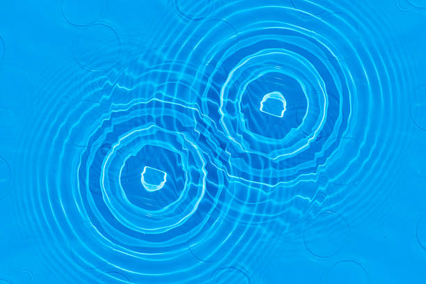 Bluewater waves on the surface ripples blurred. Defocus blurred transparent blue colored clear calm water surface texture with splash and bubbles. Water waves with shining pattern texture background.