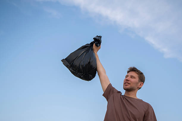 Jakarta, Indonesia - April 29, 2023: Men scavengers or used goods collectors collecting used plastic bottles to sell to second-hand goods collectors