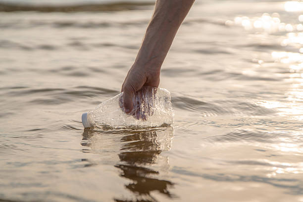 istock Hand collects plastic bottle from ocean water 2252907803