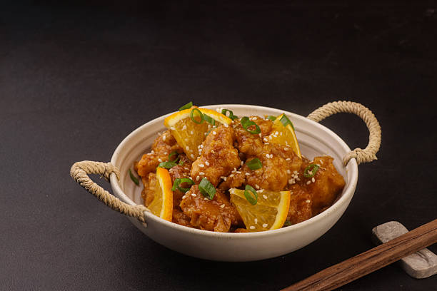 istock Orange chicken is a popular Chinese-inspired dish made with crispy fried chicken pieces coated in a glossy, sweet and tangy orange-flavored sauce, typically prepared with fresh orange juice, zest, soy sauce, sugar, and garlic, creating a rich balance of c 2252911140